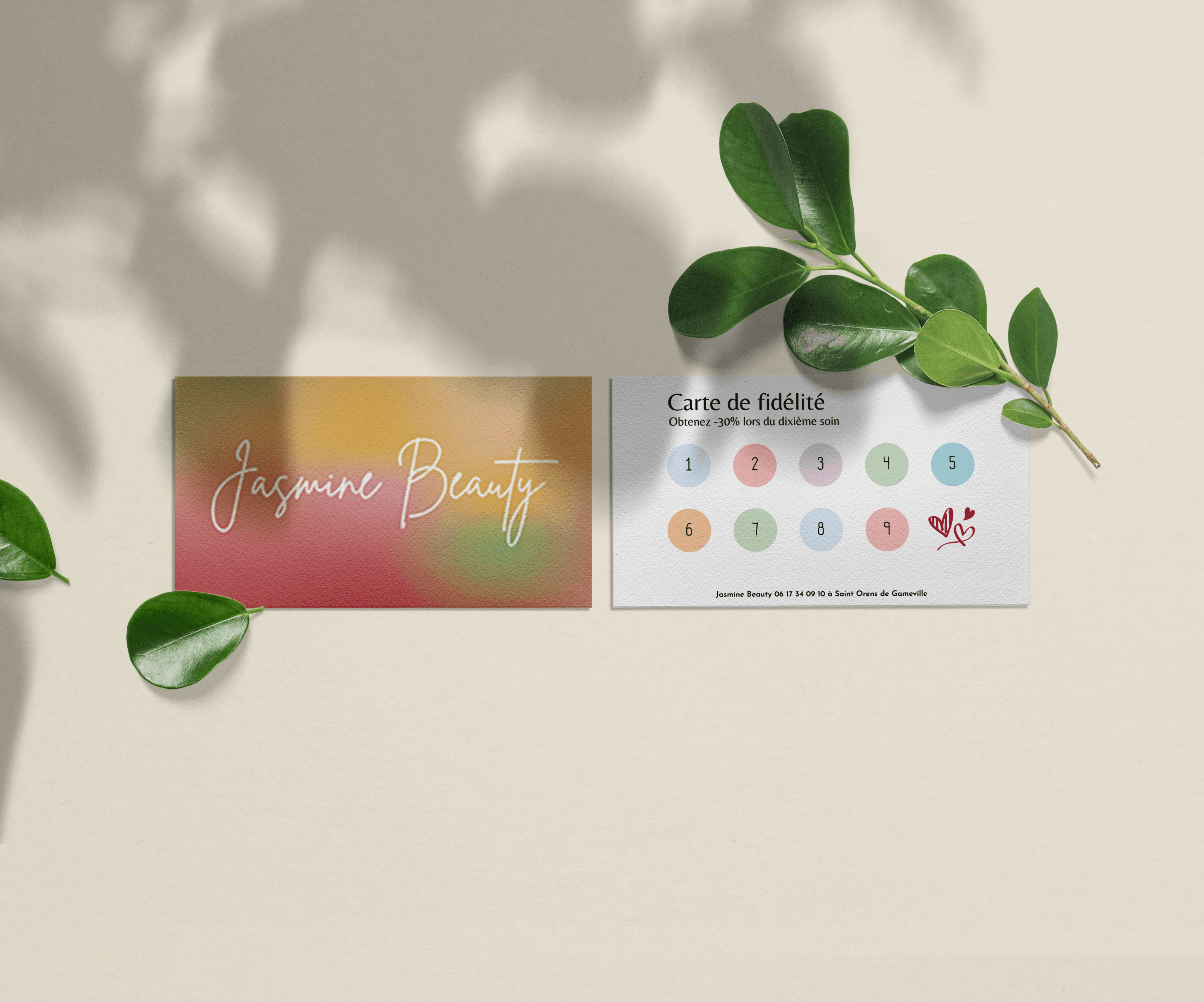 Carte de fidélité Jasmine Beauty posée avec des feuilles vertes